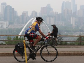 A cyclist wears a mask to protect against wild fire smoke as they their way along Saskatchewan Drive in Edmonton, Friday May 19, 2023. Photo by David Bloom