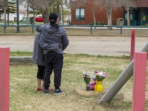 Family members leave a teddy bear and flowers near the scene where a man fatally attacked and stabbed a mother and child outside Crawford Plains School near 42 Street and 12 Avenue on Friday afternoon. Police found the woman dead while the 11-year-old was injured but still alive, but died later in hospital. Taken on Saturday, May 6, 2023, in Edmonton. Greg Southam-Postmedia