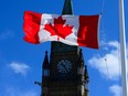 A Canada flag is pictured with the Peace Tower on Parliament Hill in Ottawa on Monday, April 12, 2021.