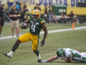 Edmonton Elks running back Kevin Brown avoids a tackle from Micha Teitz of the Saskatchewan Roughriders in the season-opener at Commonwealth Stadium on June 11, 2023.
