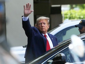 Former U.S. President Donald Trump waves after he appeared for his arraignment in Miami, Florida, on June 13, 2023. Trump pleaded not guilty to 37 federal charges including possession of national security documents after leaving office, obstruction, and making false statements.