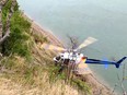 An RCMP helicopter crew rescues a 78-year-old woman at the south end of Gleniffer Lake on Thursday. The woman had been missing for four days after wandering away from a nearby campground.