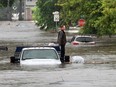 A man stands on a flatbed trailer, stranded after his truck was submerged by the rapidly rising Highwood River in High River on June 20, 2013.