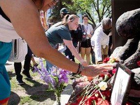 Mourners lay flowers at a homeless memorial service in Edmonton
