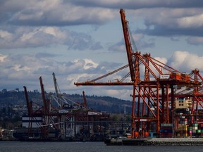 A seaplane prepares to land on the harbour as gantry cranes used to load and unload cargo containers are seen at port, in Vancouver, on Tuesday, April 25, 2023. The union representing port workers in British Columbia says it has issued 72-hour strike notice, saying they are ready to walk off the job on Saturday.