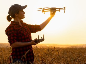 A farmer prepared to launch a drone over a field.