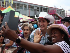 Prime Minister Justin Trudeau makes his way through a swarm of thousands of people, stoping to take a picture with Cola Makanjula, on Day 1 of the Calgary Stampede on Friday, July 7.
