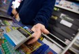 A corner store owner in St. Thomas, Ont, holds a package of cigarettes.