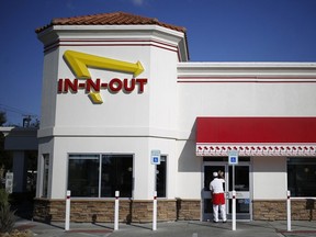 An employee cleans the front door of an In-N-Out Burger restaurant in Fort Worth, Texas.