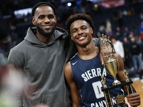 FILE - LeBron James, left, poses with his son Bronny after Sierra Canyon beat Akron St. Vincent - St. Mary in a high school basketball game, Saturday, Dec. 14, 2019, in Columbus, Ohio. Bronny James, son of NBA superstar LeBron James, was hospitalized after going into cardiac arrest while participating in a practice at Southern California on Monday, July 24, 2023.