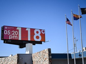 A billboard displays a temperature of 118 degrees Fahrenheit (48 degrees Celsius) during a record heat wave in Phoenix, Ariz. on July 18, 2023.