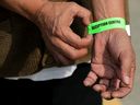 Ron Dodman, evacuee from Yellowknife, displays the evacuee wristband he received at the wildfire evacuation centre at the Edmonton Expo Centre on Aug. 19, 2023. 
