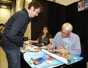 Charles Martinet (R) signs an autograph for Tim Brownrigg during the opening day of Comiccon in Ottawa, May 09, 2014.