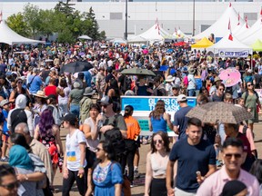 Crowds pack the grounds of the Heritage Festival, with vendor tents in the background