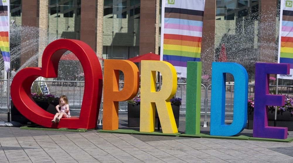 A child poses for a picture in front of the pride sign at the Edmonton Pride Festival at Churchill Square on Saturday, Aug. 26, 2023 in Edmonton.
