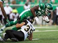 Former Saskatchewan Roughriders running back #33 Jerome Messam is seen here in this July 5, 2018 file photo being brought down by Hamilton Tiger-Cats #35 Mike Daly during CFL game at Mosaic Stadium. He was released by the team the same month after being charged with voyeurism in Alberta. He now faces a similar charge in Saskatchewan.
