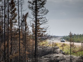 Fire activity along a key Northwest Territories highway is expected to kick up in the coming days, while Mounties say they'll stop a potentially large group from trying to re-enter when an evacuation order is still in effect. Evacuees from Yellowknife, territorial capital of the Northwest Territories, make their way along highway 3, at the edge of a burned forest, on their way into Ft. Providence, Thursday, Aug. 17, 2023.