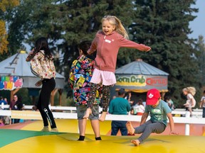 Chilcdren jump up and down on a large inflated outdoor surface