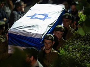 Israeli Defense Forces (IDF) soldiers carry the coffin with the remains of their comrade Noam Elimeleh Rothenberg during his funeral at Mount Herzel Cemetery in Jerusalem on October 10, 2023.