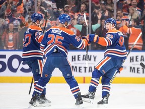 Edmonton Oilers' Brett Kulak (27), Darnell Nurse (25) and Ryan Nugent-Hopkins (93) celebrate a goal against the Anaheim Ducks.
