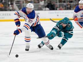 Connor McDavid #97 of the Edmonton Oilers skates with the puck pursued by Luke Kunin #11 of the San Jose Sharks