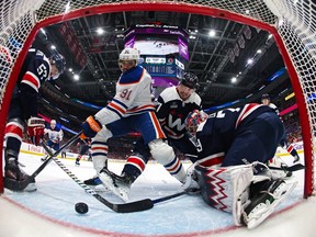 WASHINGTON, DC - NOVEMBER 24: Evander Kane #91 of the Edmonton Oilers scores a goal on goalie Charlie Lindgren #79 and Alexander Alexeyev #27 of the Washington Capitals during the first period at Capital One Arena on November 24, 2023 in Washington, DC.