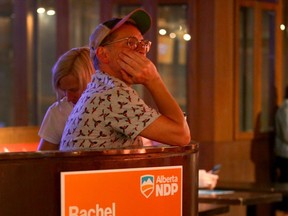 NDP supporters are bathed in orange light as they watch election results at the NDP watch party at the Palace Theatre in downtown Calgary on May 29.