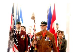 Holding an eagle staff, Chuck Isaacs, president of the Aboriginal Veterans Society of Alberta, prepares to lead a group of indigenous veterans into the City of Edmonton's National Indigenous Veterans Day event, at city hall on Wednesday, Nov. 8, 2023. The City of Edmonton in partnership with the Aboriginal Veterans Society of Alberta hosted the event to recognize the sacrifices and contributions that First Nations, Inuit and Metis veterans have made in service of Canada.