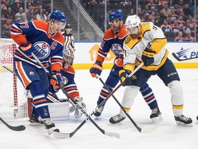 Nashville Predators' Ryan O'Reilly (90) and Edmonton Oilers' Connor McDavid (97) battle for the rebound during first period NHL action in Edmonton on Saturday, Nov. 4, 2023.