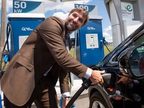 Canadian Heritage Minister Steven Guilbeault plugs in an electric car at a news conference Wednesday, July 28, 2021 in Laval, Quebec.
