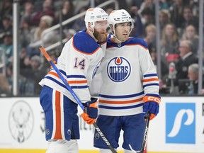 Evan Bouchard and Mattias Ekholm celebrate a goal in the middle of the ice.