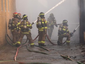 Edmonton Fire Rescue Services firefighters extinguish a fire in an abandoned building near 101 Street and 106 Avenue in Edmonton, on April 10, 2022. A previous fire at the site destroyed the closed Mila Pub.