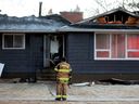 Firefighters work at the scene of a house fire on 156 Street north of 77A Avenue, in Edmonton Friday Dec. 1, 2023. 