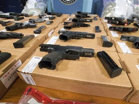 Police display guns seized at the Canada-U.S. border. Critics say the federal gun control legislation Bill C-21 will be ineffective since the vast majority of crime guns in Canada come from the United States.