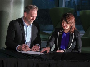 Mark Holland, Canada's Minister of Health and Adriana LaGrange, Minister of Health for Alberta sign a healthcare funding agreement in Calgary on Thursday, December 21, 2023.