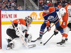 Philadelphia Flyers goalie Carter Hart makes the save as Edmonton Oilers' Zach Hyman (18) and Travis Sanheim (6) battle for the rebound.