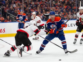 Connor McDavid tries to carry the puck around a Senators defender