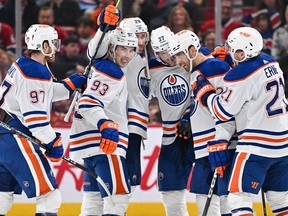 Evan Bouchard of the Edmonton Oilers celebrates his overtime goal with teammates Connor McDavid, Ryan Nugent-Hopkins, Leon Draisait, Warren Foegele and Adam Erne at the Bell Centre on Jan. 13, 2024 in Montreal. The Edmonton Oilers defeated the Montreal Canadiens 2-1 in overtime.
