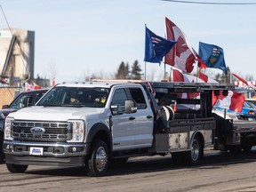 Vehicles adorned with flags and decals associated with the Freedom Convoy pull into a trucking yard in Lethbridge, Alta., for a gathering following a convoy to the Coutts border crossing on Saturday, Jan. 27, 2024.