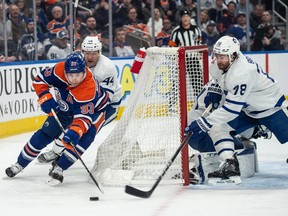 Ryan Nugent-Hopkins circles behind the Maple Leafs net pursued by a Toronto defender