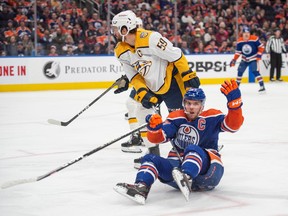 Connor McDavid (97) of the Edmonton Oilers is pulled down by Roman Josi(59) of the Nashville Predators at Rogers Place in Edmonton on Saturday, Jan. 27, 2024.
