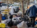 City workers remove items from an encampment near 95 Street and 106 avenue on Friday, Jan. 19, 2024 in Edmonton.     