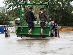 Volunteers help evacuate campers from the Highland Campground in Fort Macleod during flooding on June 18, 2014.