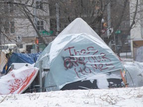 a tent in a homeless encampment in edmonton says 'these are our homes'