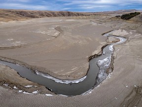 The Oldman River runs through a bed of thick silt to the nearly dry Oldman Reservoir north of Cowley on Dec. 18, 2023.