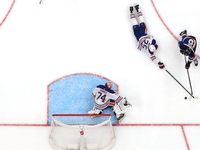 Edmonton Oilers Darnell Nurse dives to stop a shot as Stuart Skinner hugs the post, as seen from overhead