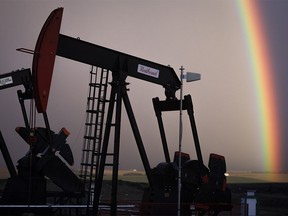 A rainbow appears to come down on pumpjacks drawing out oil and gas from wells near Calgary on Monday, Sept. 18, 2023.