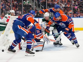 Oilers and Wild battle for the puck around the OIlers net
