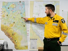 Alberta Wildfire's Cory Davis points out automatic weather stations and lightning sensors across the province during a media tour of the Alberta Wildfire co-ordination centre in Edmonton on Monday, March 11, 2024.