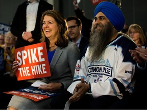 Danielle Smith sits next to MP Tim Uppa;